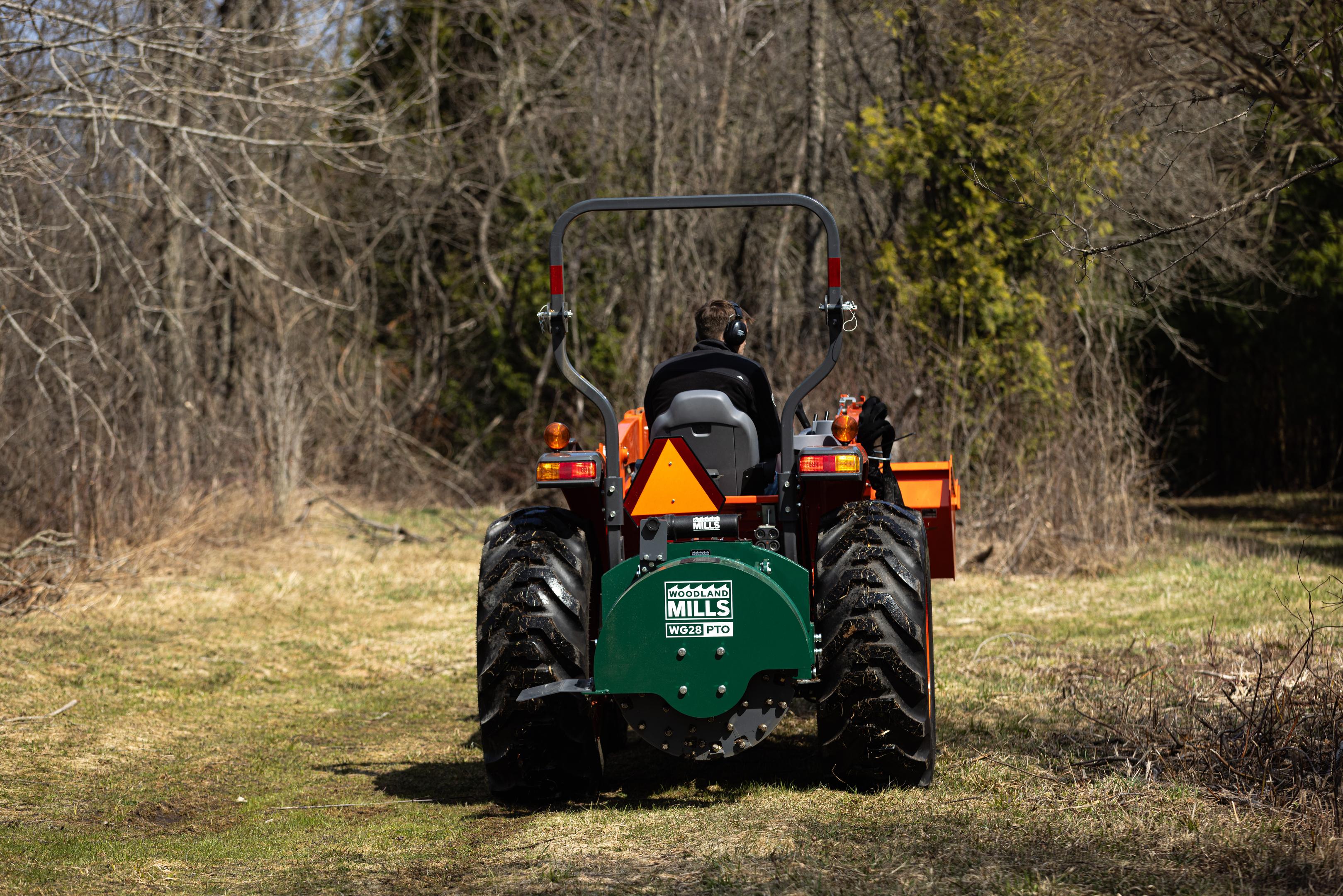 A Woodland Mills stump grinder on the back of a tractor.