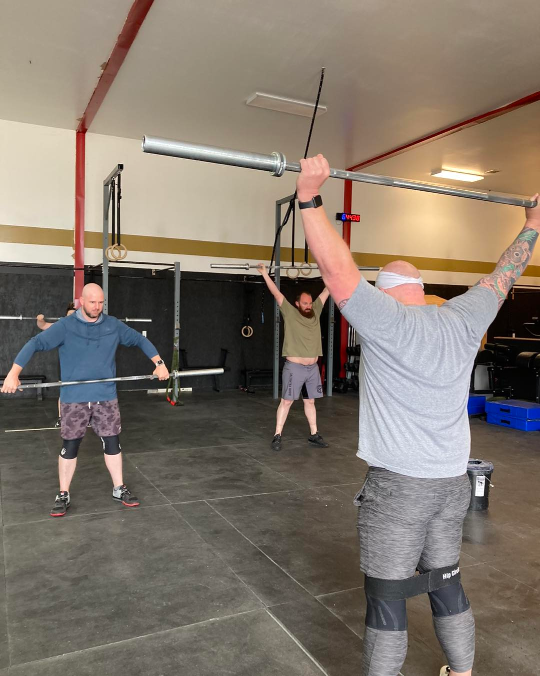 Group of people of different ages and skill levels doing CrossFit exercises in a gym