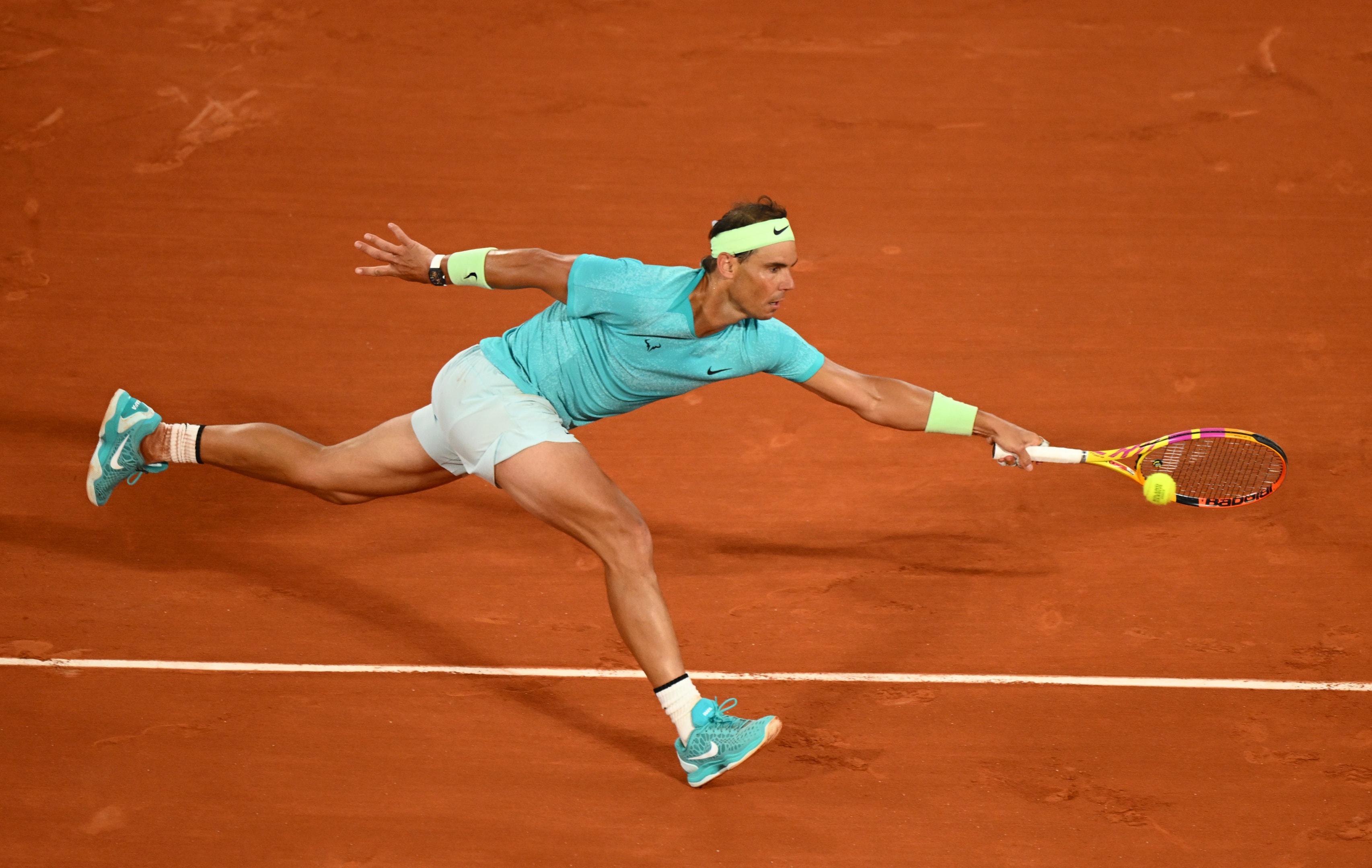 Rafael Nadal stretches for a forehand against Alexander Zverev at the 2024 French Open at Roland Garros.