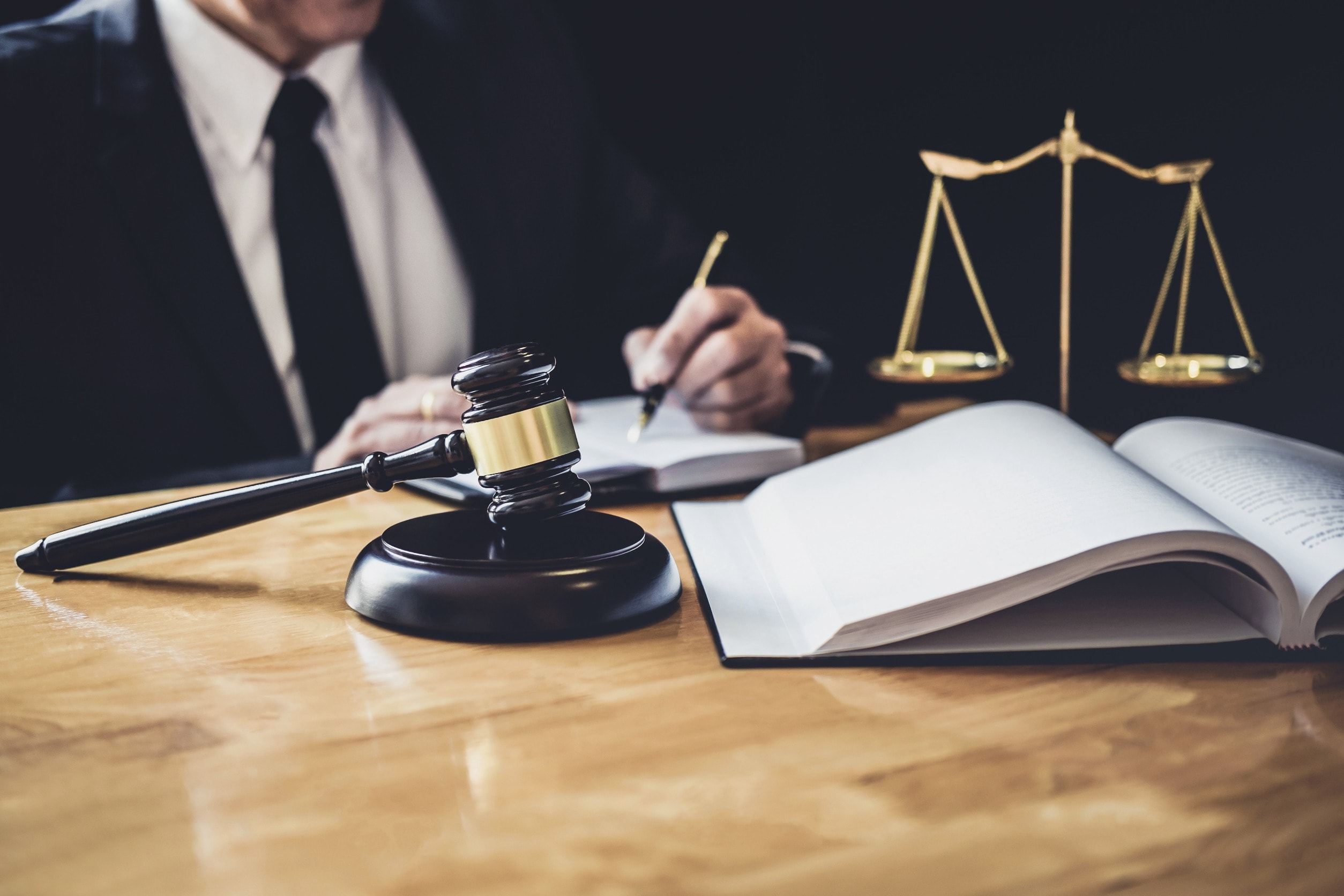 A pressure sore claims solicitor writing in a book behind a gavel
