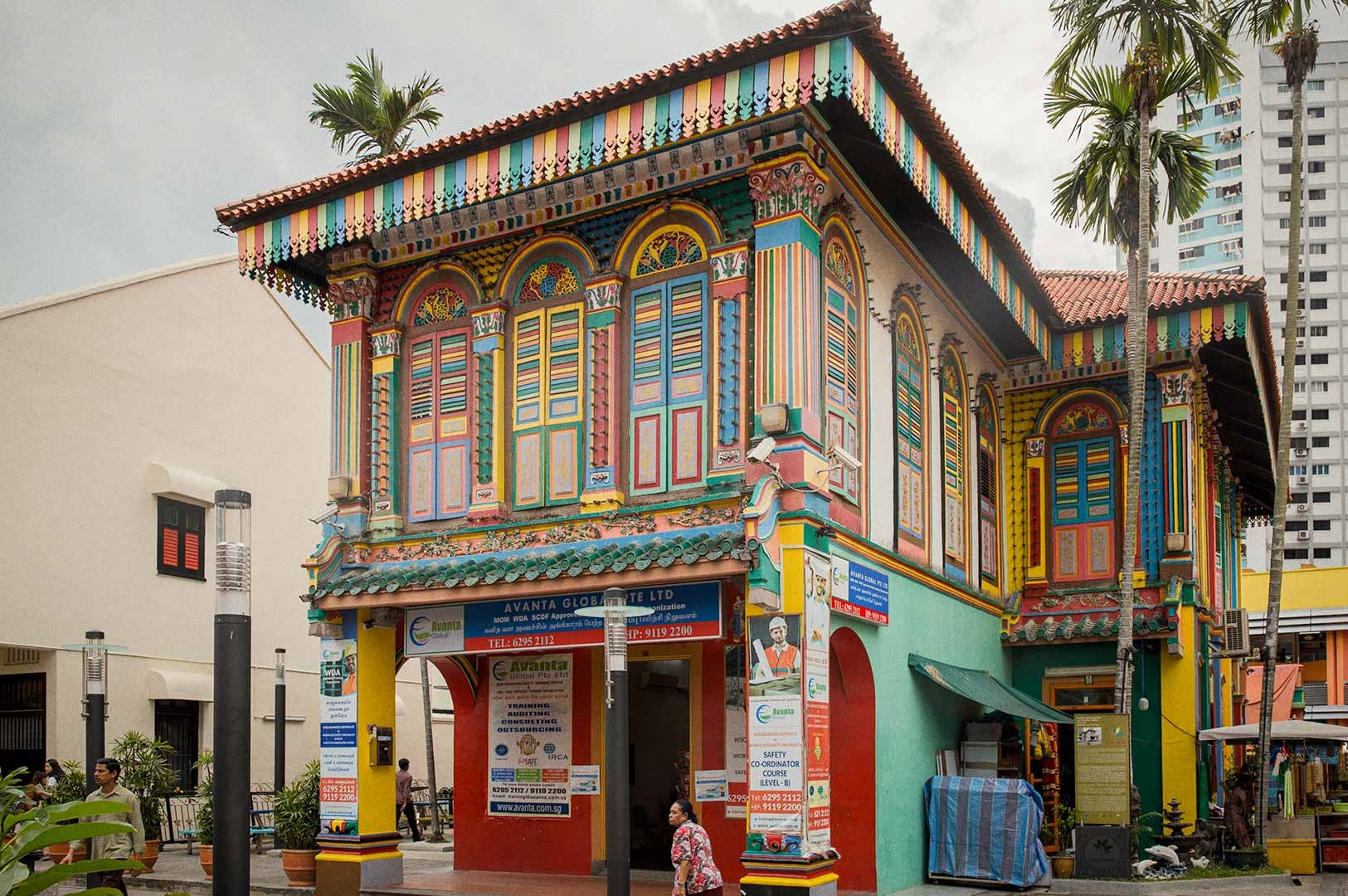 The brightly painted House of Tan Teng Niah featuring colorful wooden shutters, ornate trim, and a two‑storey façade set among palm trees.