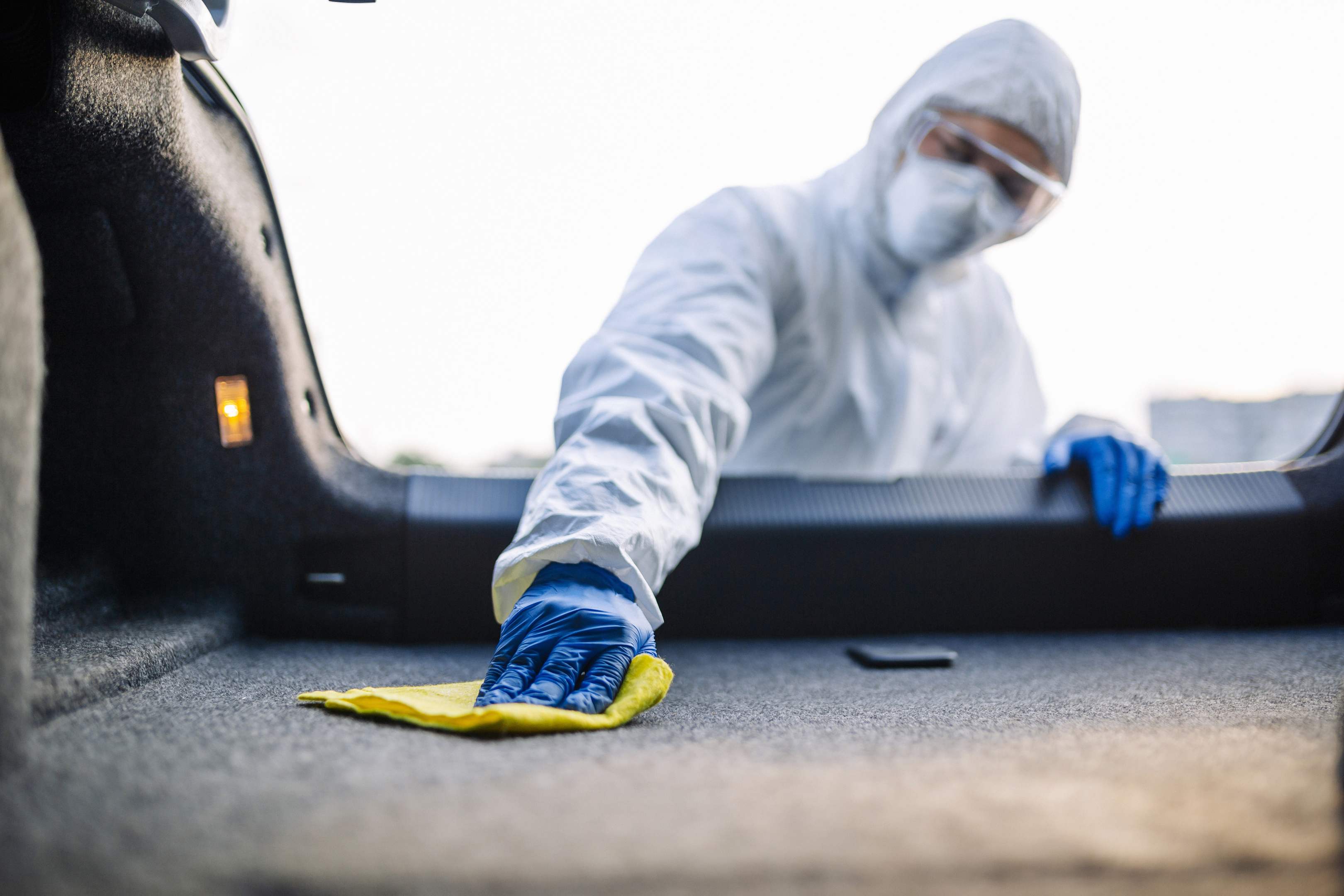 Cleaning the inside of a car wearing PPE