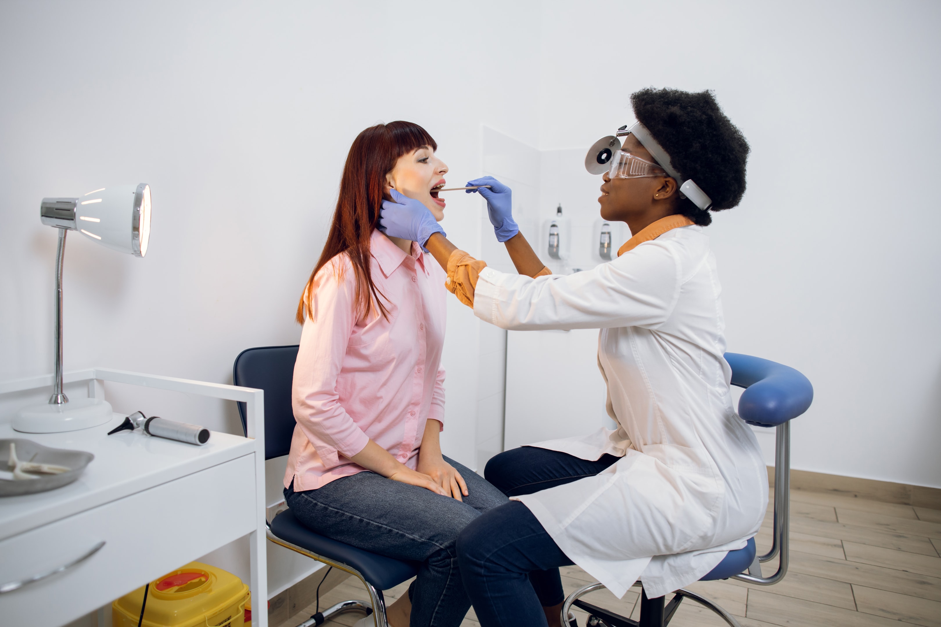 An image of an oral surgeon and a young woman checking on her front teeth.