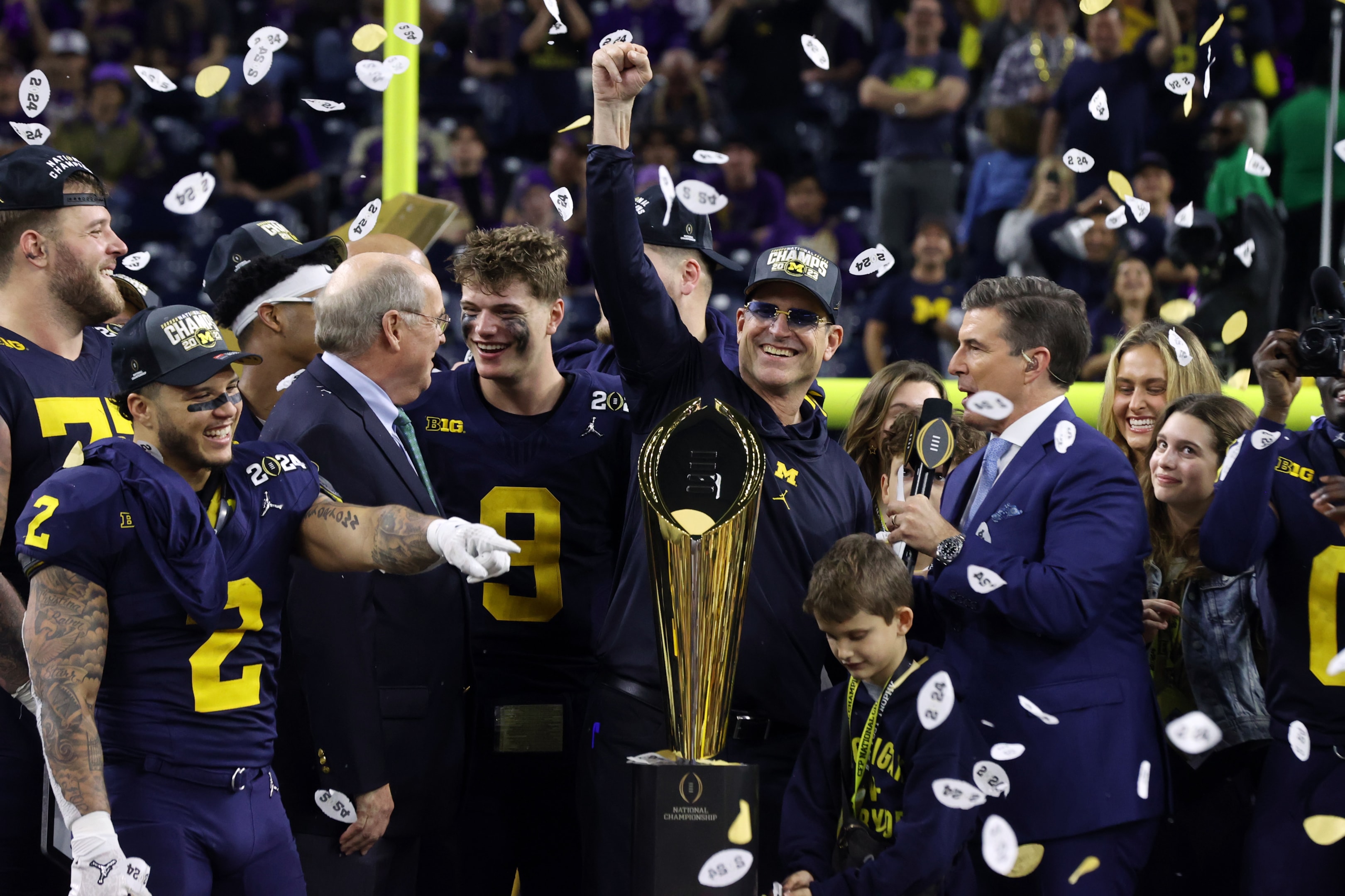 Michigan Wolverines head coach Jim Harbaugh is presented the CFP National Championship Trophy after defeating the Washington Huskies during the 2024 CFP National Championship game at NRG Stadium on January 8, 2024 in Houston,Texas.