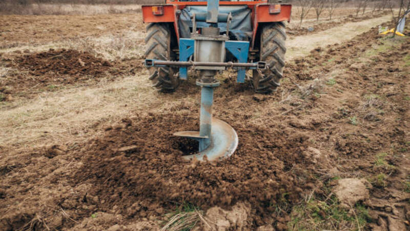 An auger drilling into the soil. 