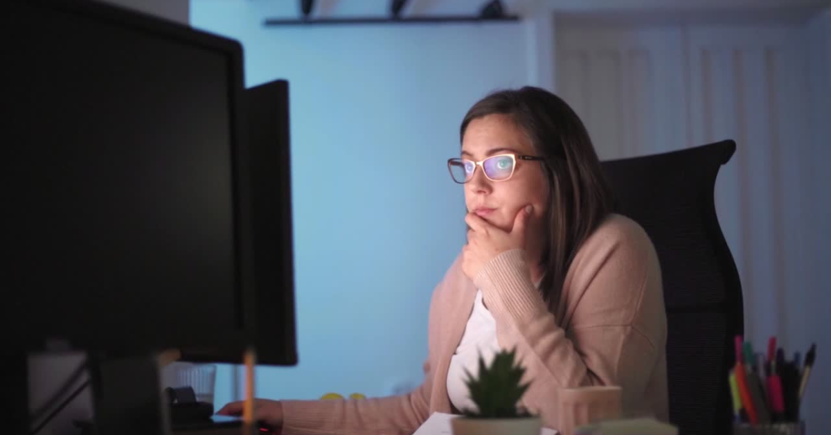 A woman in front of a computer using onlyfans tax calculator.