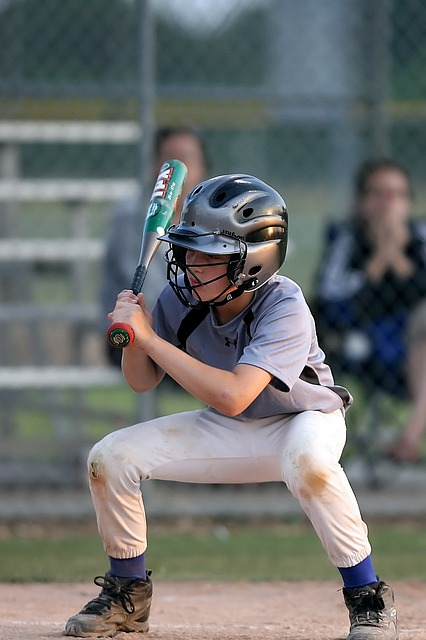 young player with a batting helmet and bat and cleats