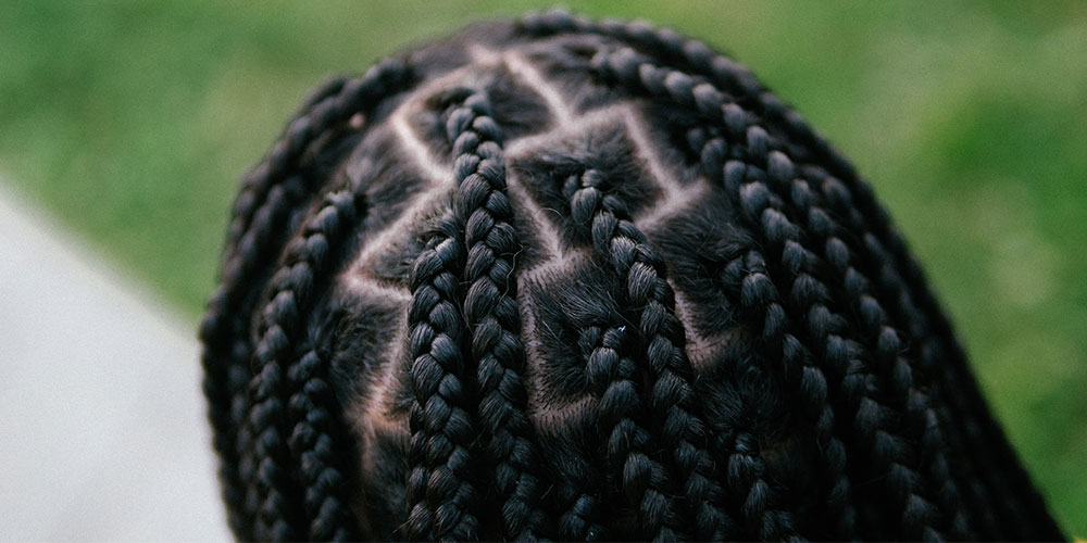 A woman with braids, using remedies for common braid-related issues