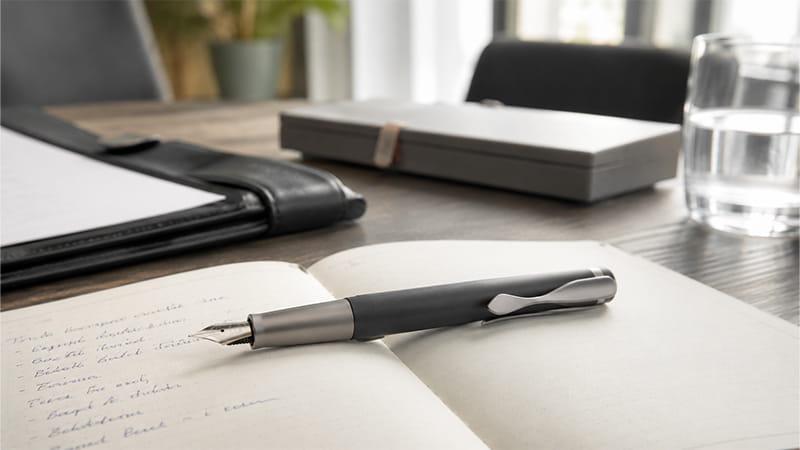 Custom fountain pen for corporate gifts displayed with a notebook in a professional office setting