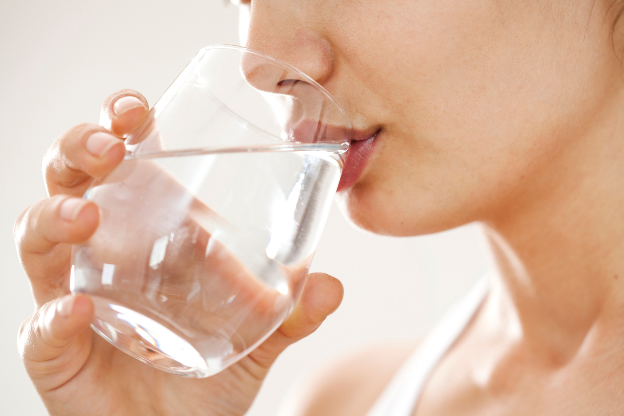 An image of a woman drinking a glass of water