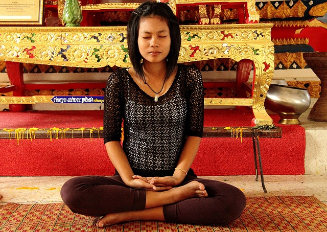 An image of a young woman meditating in a temple. 