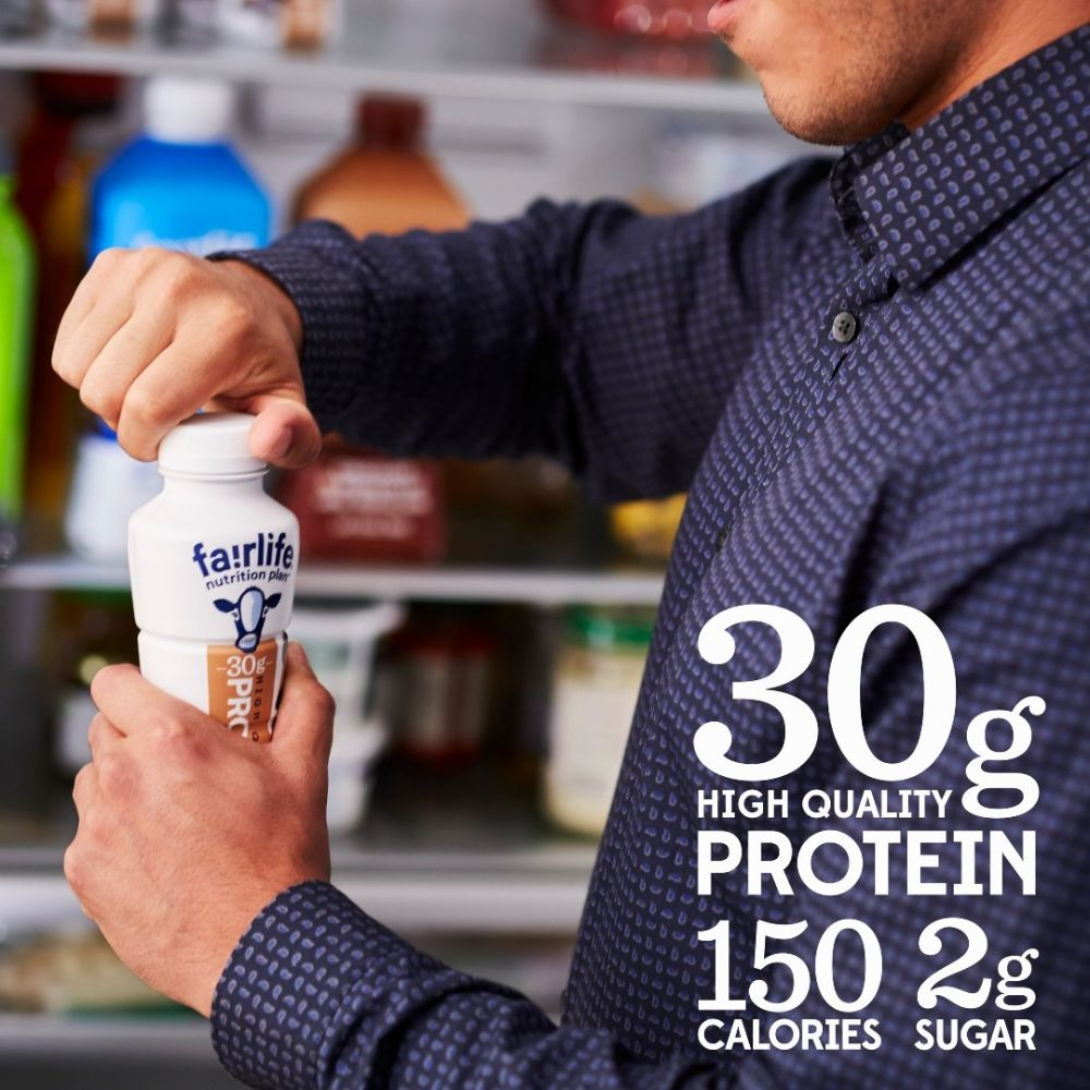 A person holding a bottle of Fairlife protein shake with a label showing the nutrition plan