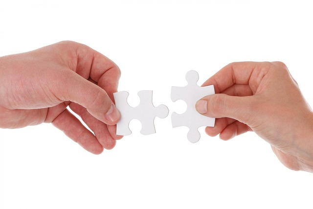 hands fitting together puzzle pieces representing how unique selling propositions attract prospective customers