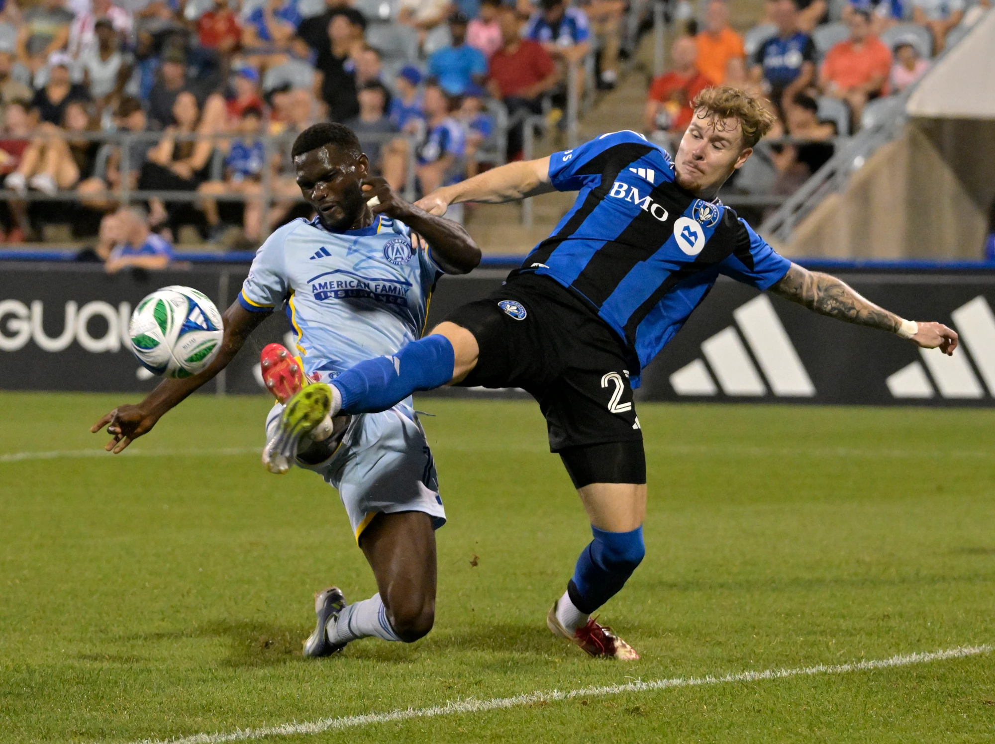 Aug 9, 2025; Montreal, Province of Quebec, CAN; CF Montreal defender Dawid Bugaj (27) kicks the ball away from Atlanta United forward Emmanuel Latte Lath (19) during the second half at Saputo Stadium.