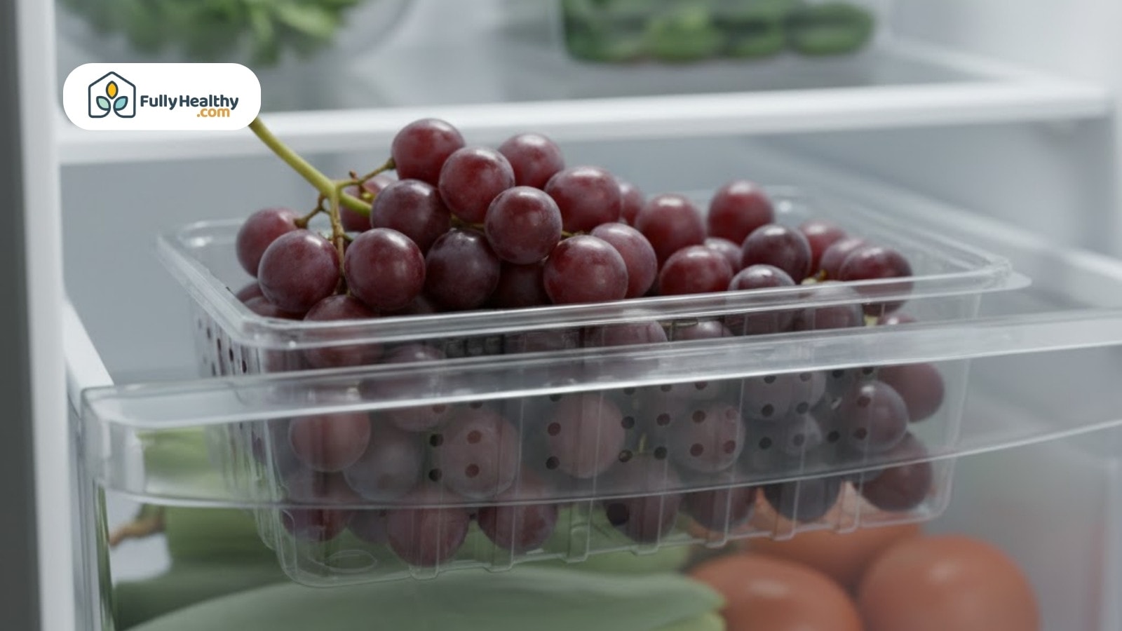Red grapes stored in ventilated plastic container on refrigerator shelf