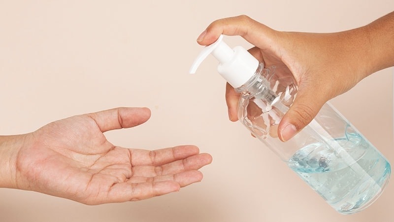 Two hands with a sanitizer in one