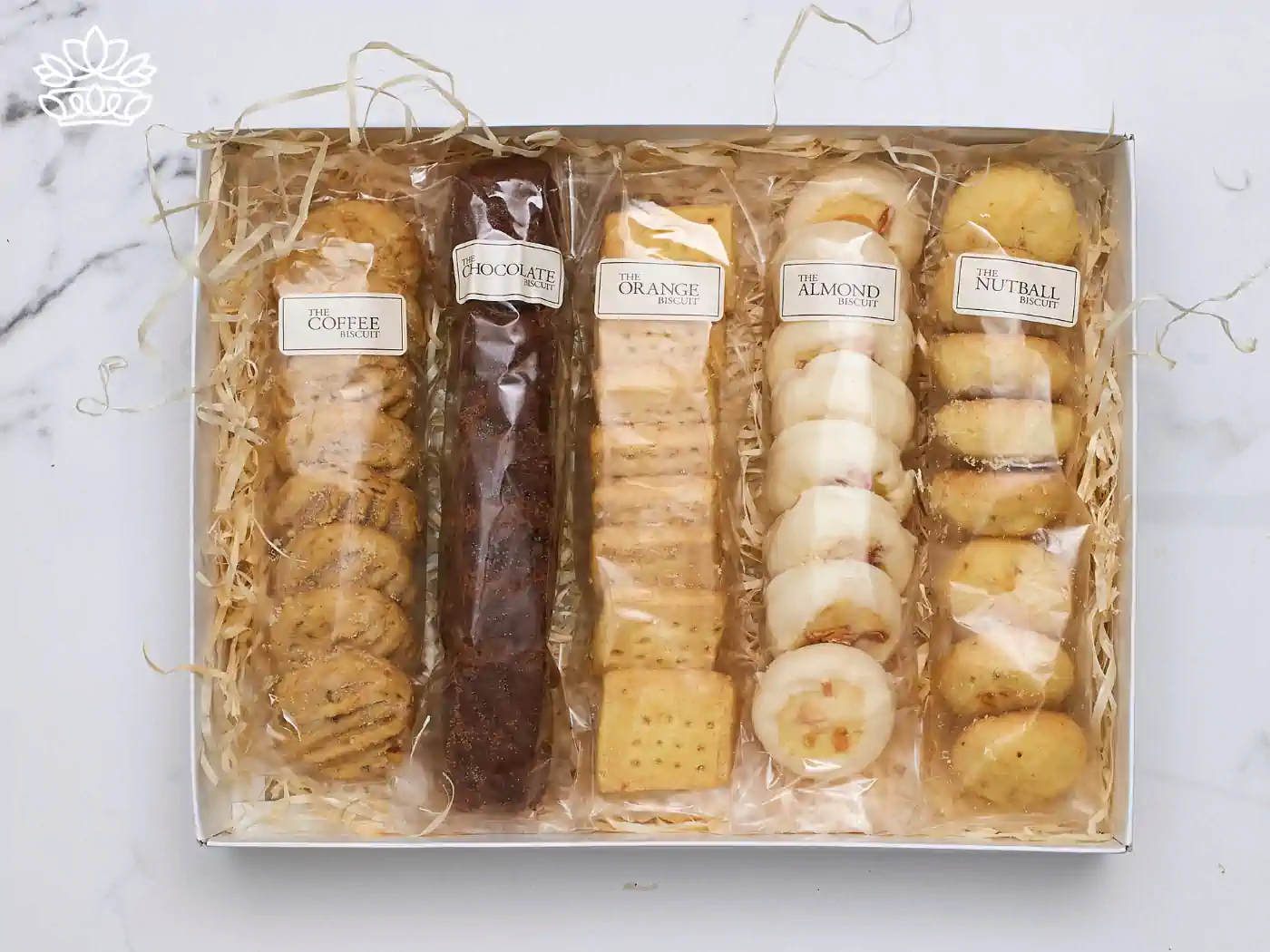 Assorted gourmet biscuit selection in a gift box, featuring flavors like coffee, chocolate, orange, almond, and nutball, elegantly presented on a marble background. Fabulous Flowers and Gifts.