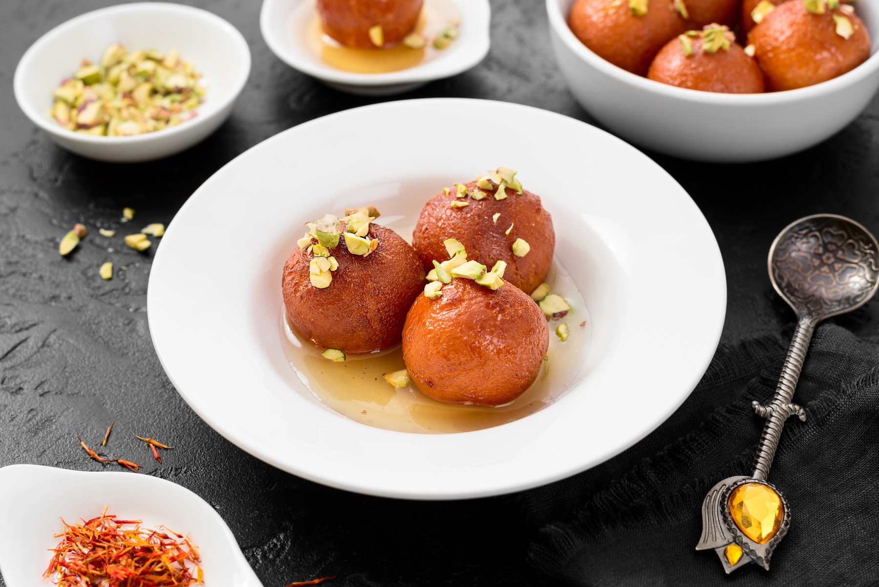 Gulab Jamun | Plate of gulab jamun garnished with saffron strands and pistachios | Himalaya Restaurant 