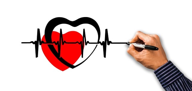 Hand drawing a heart and a heart rate graph