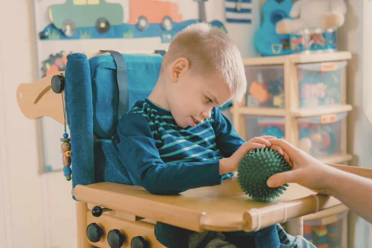 Child with special needs playing with a sensory ball