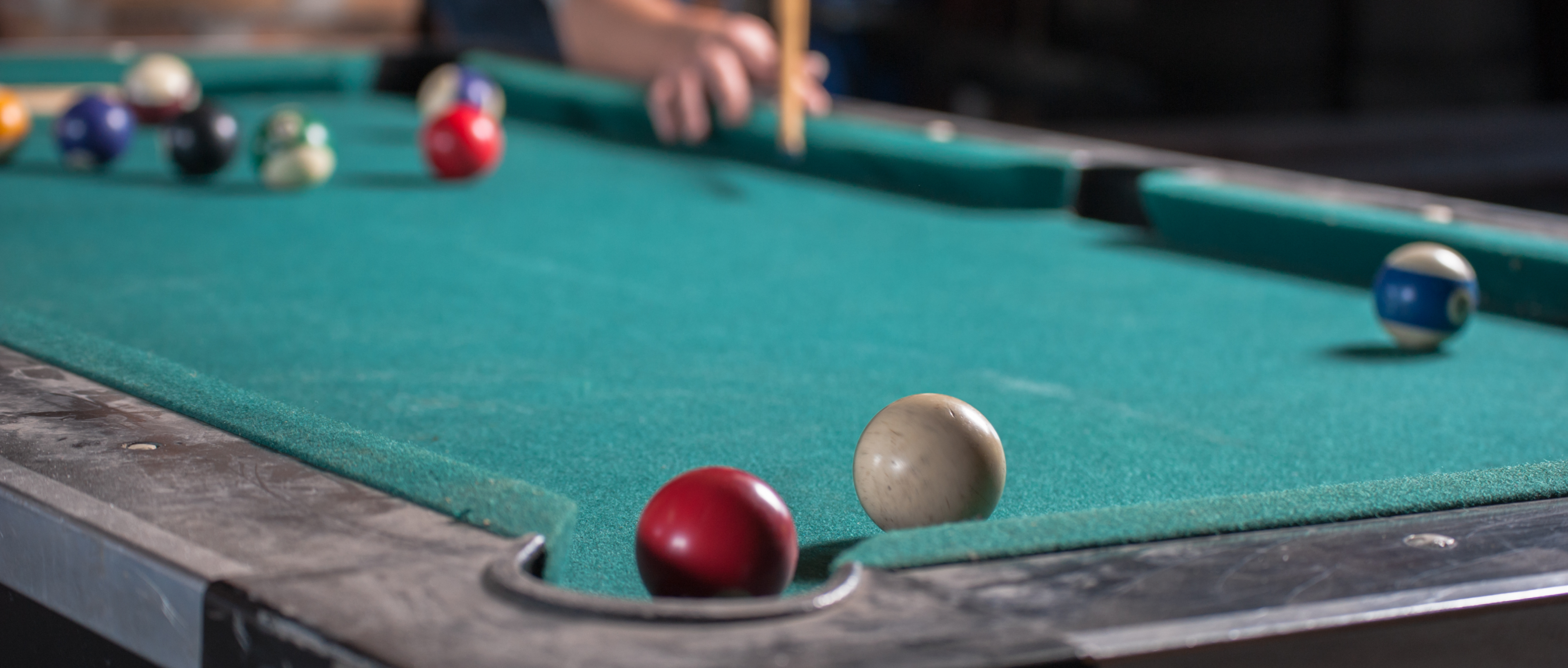 Billiard balls and a cue on a billiard table.