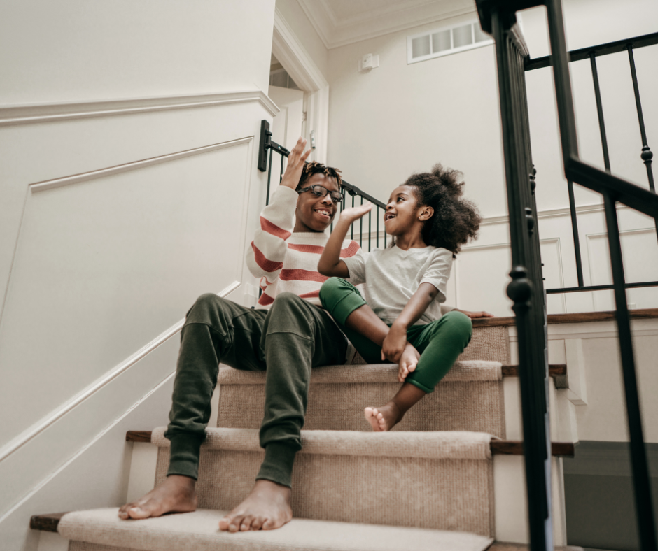 two kids high-five on stairs