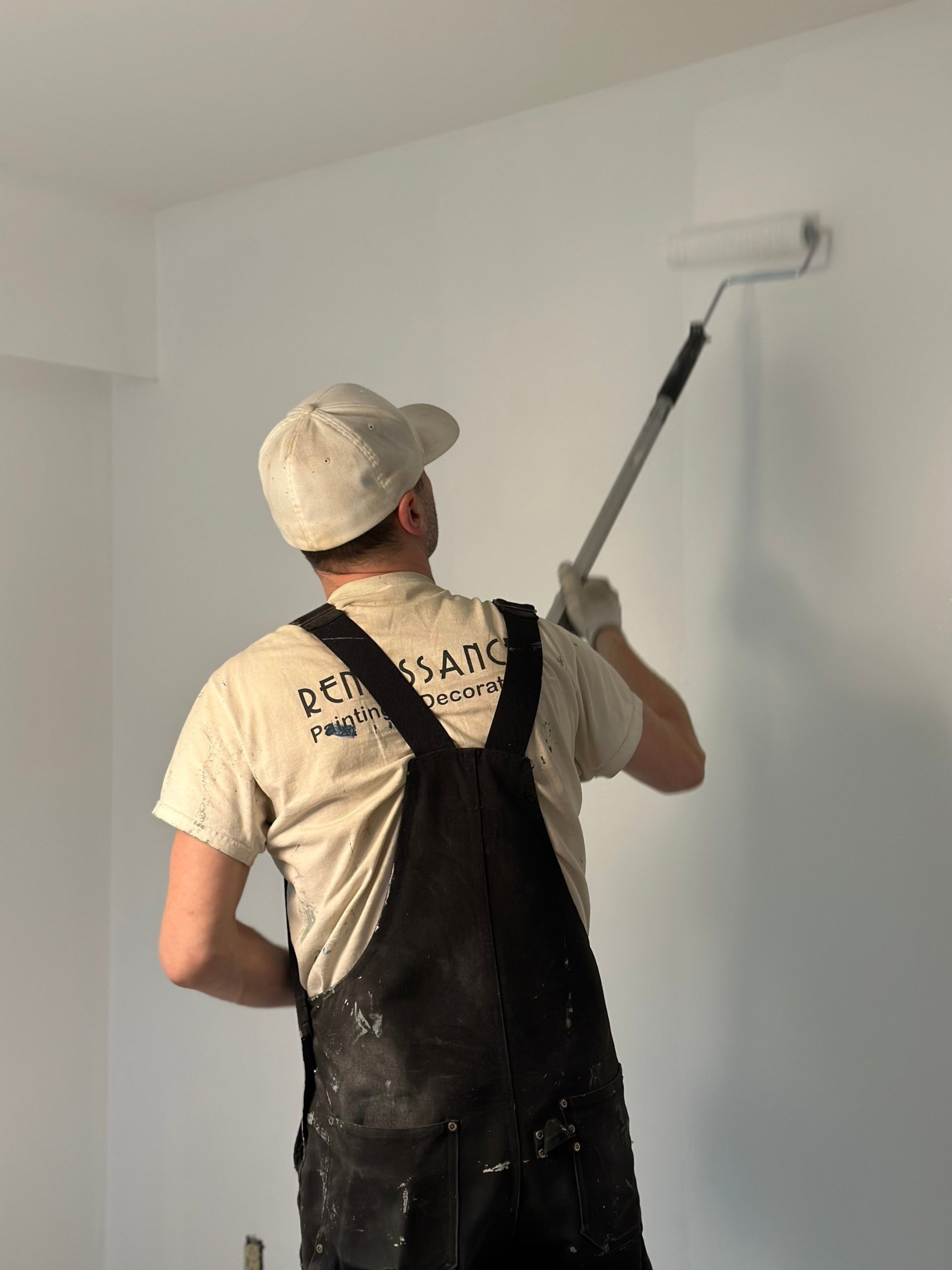 A professional painter painting a wall in a house