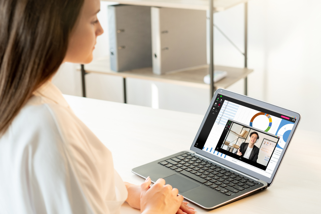 Remote employee attending a virtual presentation with charts and analytics displayed on screen