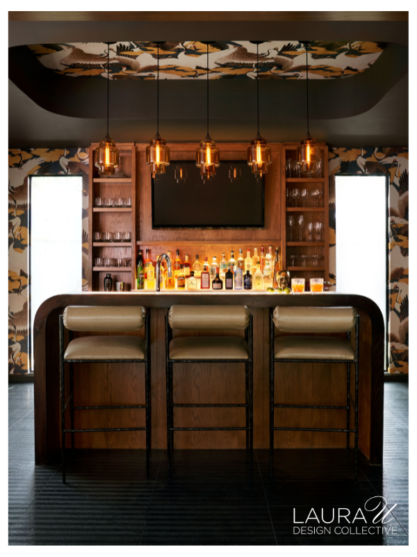 Custom walnut home bar with layered pendant lighting and illuminated bottle display at River Oaks Modern.