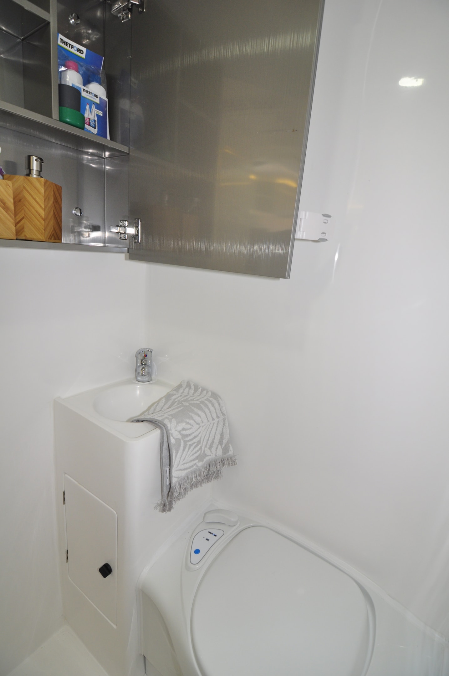 The on board ensuite has handy wall mounted shelving, a mirrored vanity cupboard with a roof hatch for ventillation.