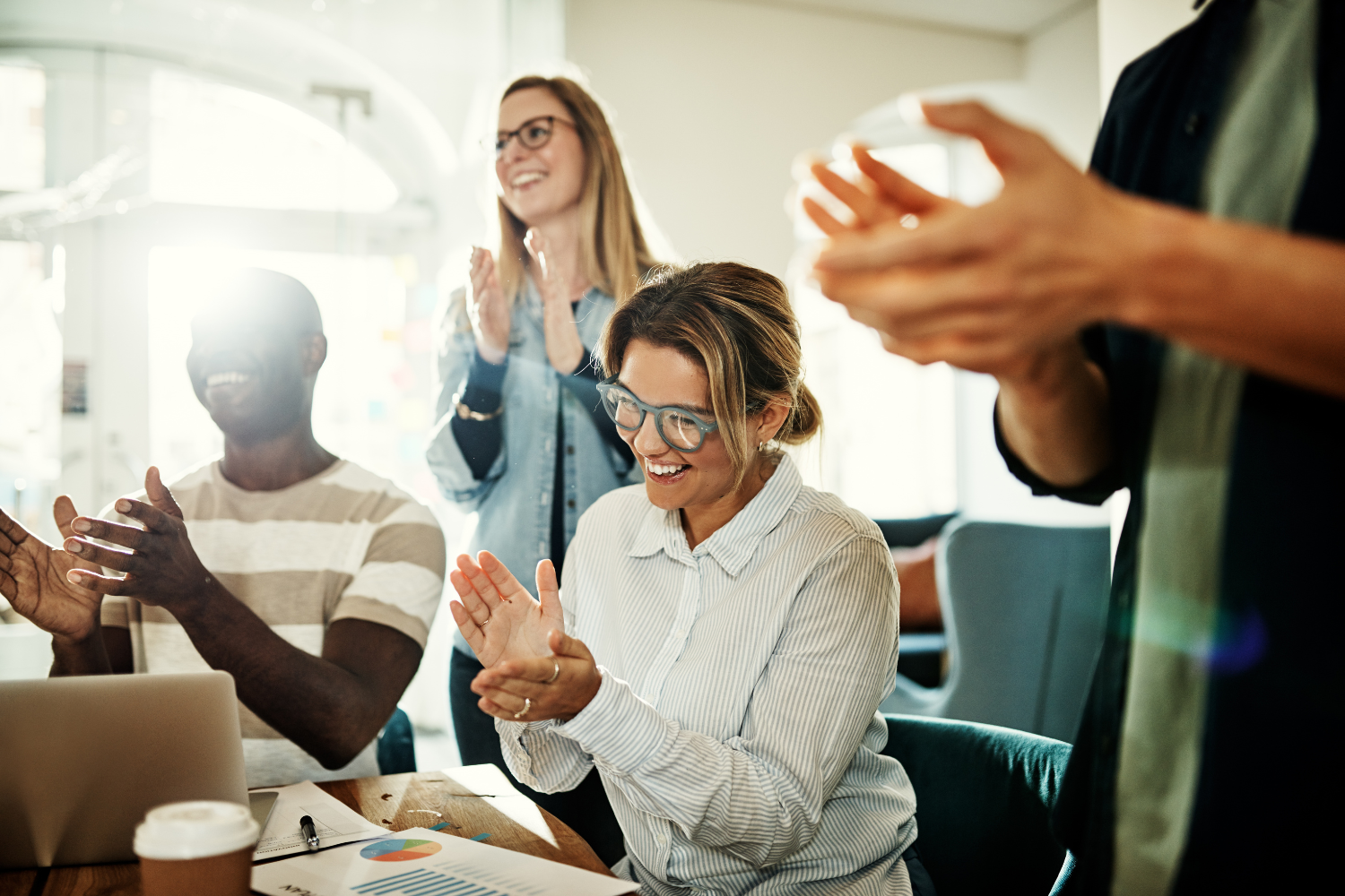 Team members applauding another coworker.