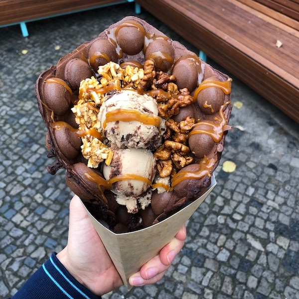 Chocolate bubble waffle made by Katchi Ice Cream, filled with Ice Cream, topped with nuts & caramel.