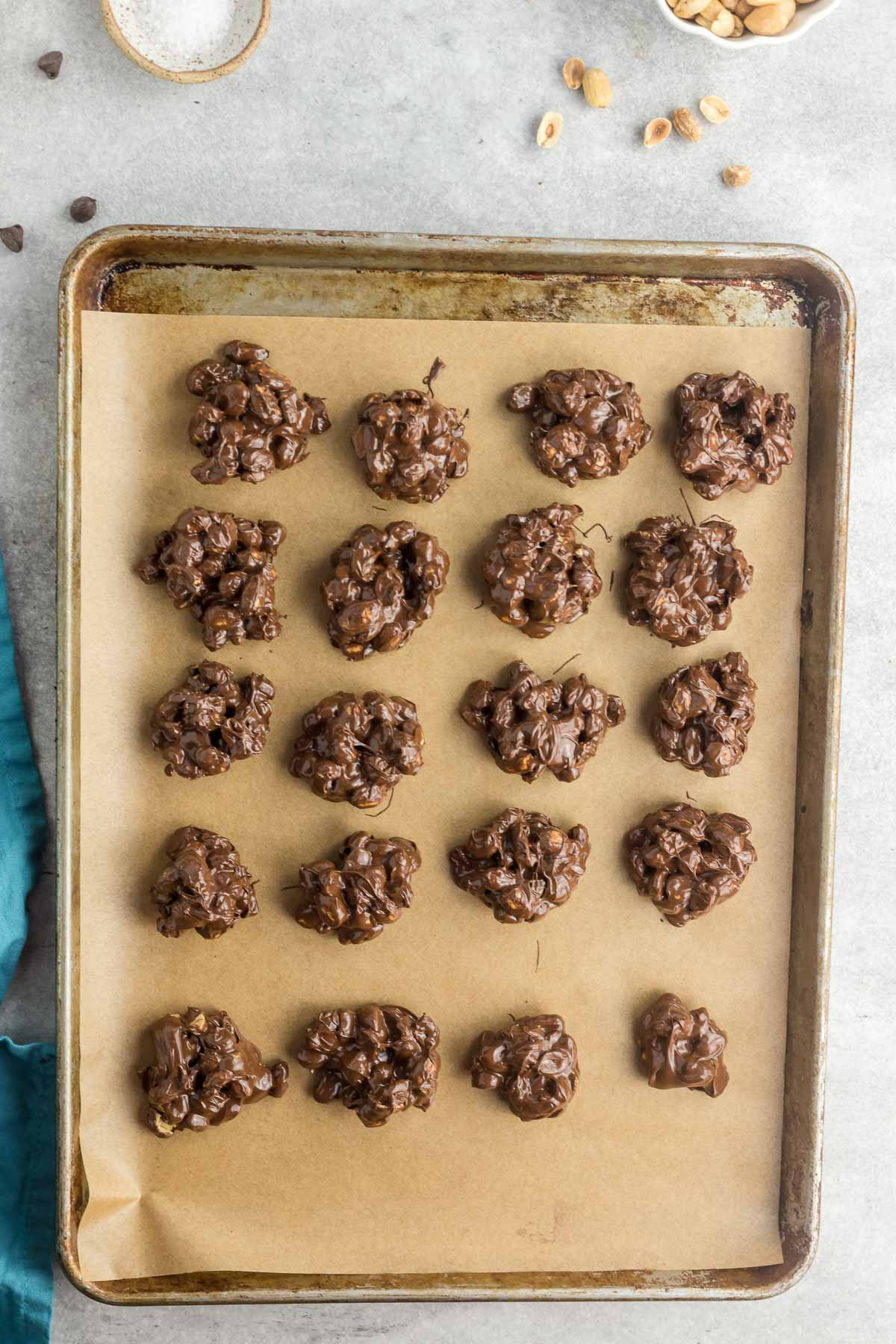 chocolate peanut clusters scooped onto parchment lined baking sheets