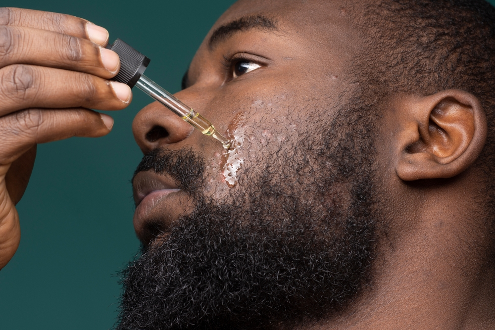 Man applying beard oil to his facial hair