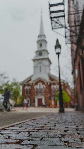 Pretty church above cobblestone streets of a New England town