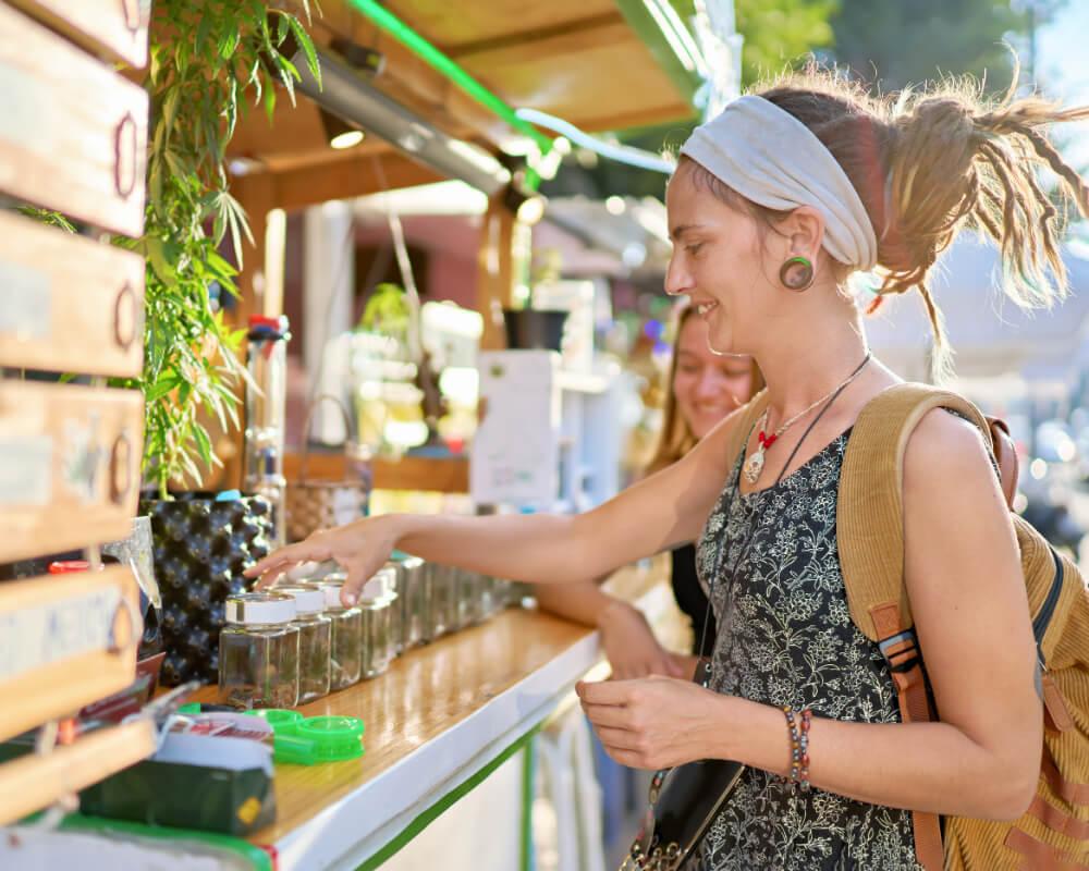 a woman buying CBD flower from a stall