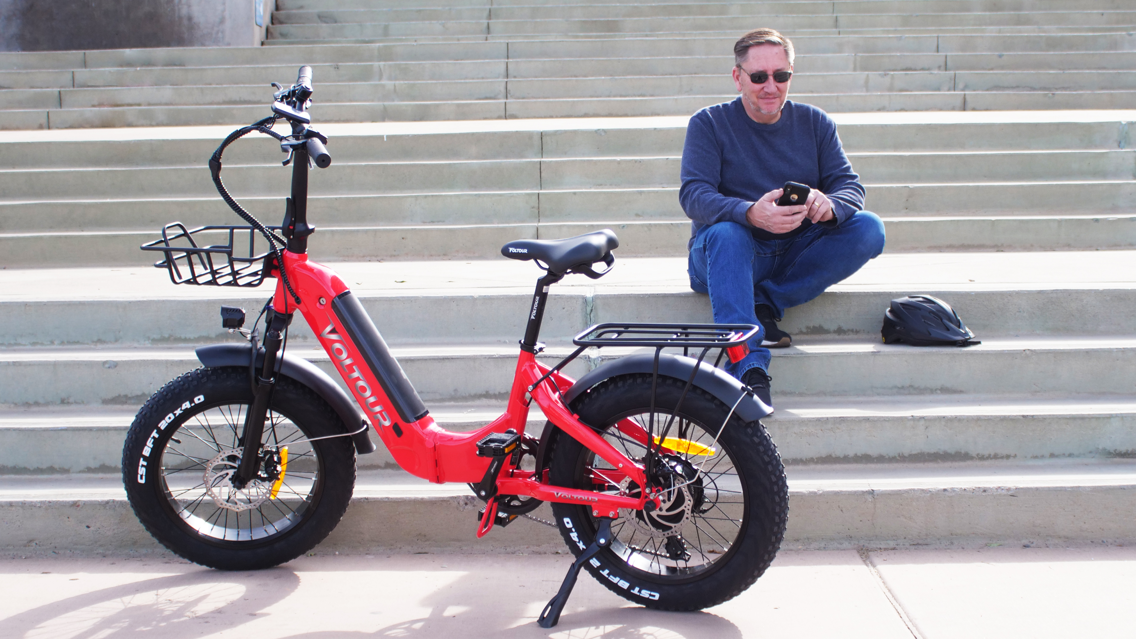 ebike with person on phone sitting on stairs