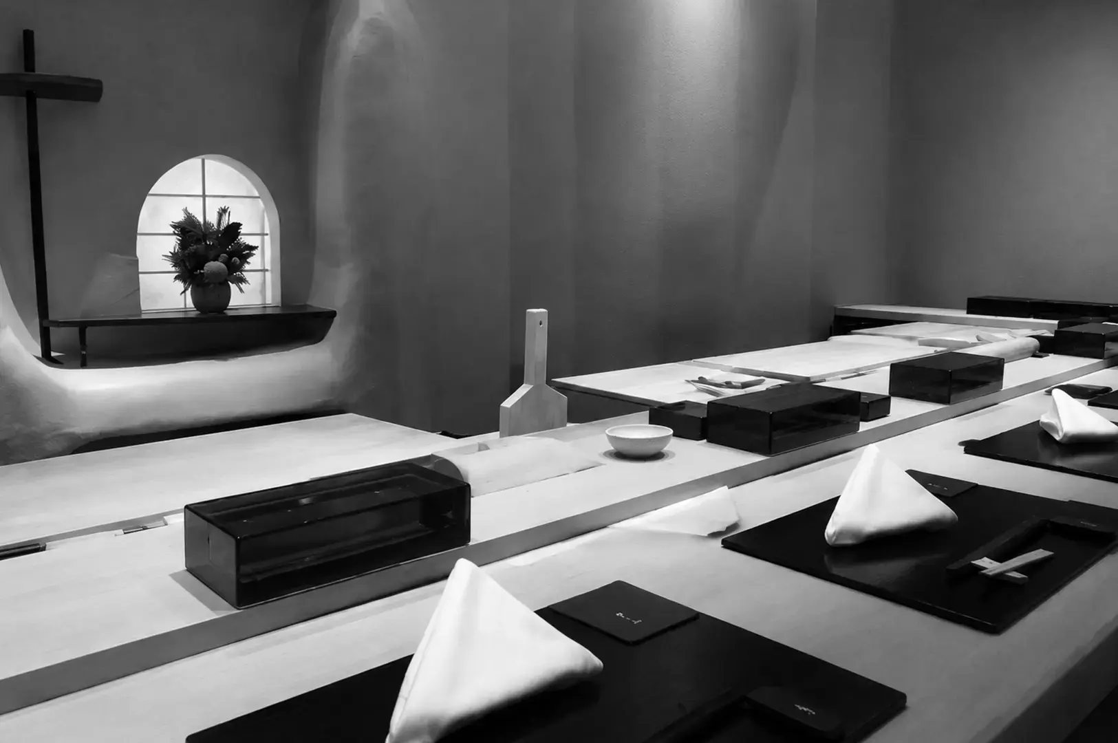 Minimalist sushi bar with counter seating and elegant Japanese-inspired decor.