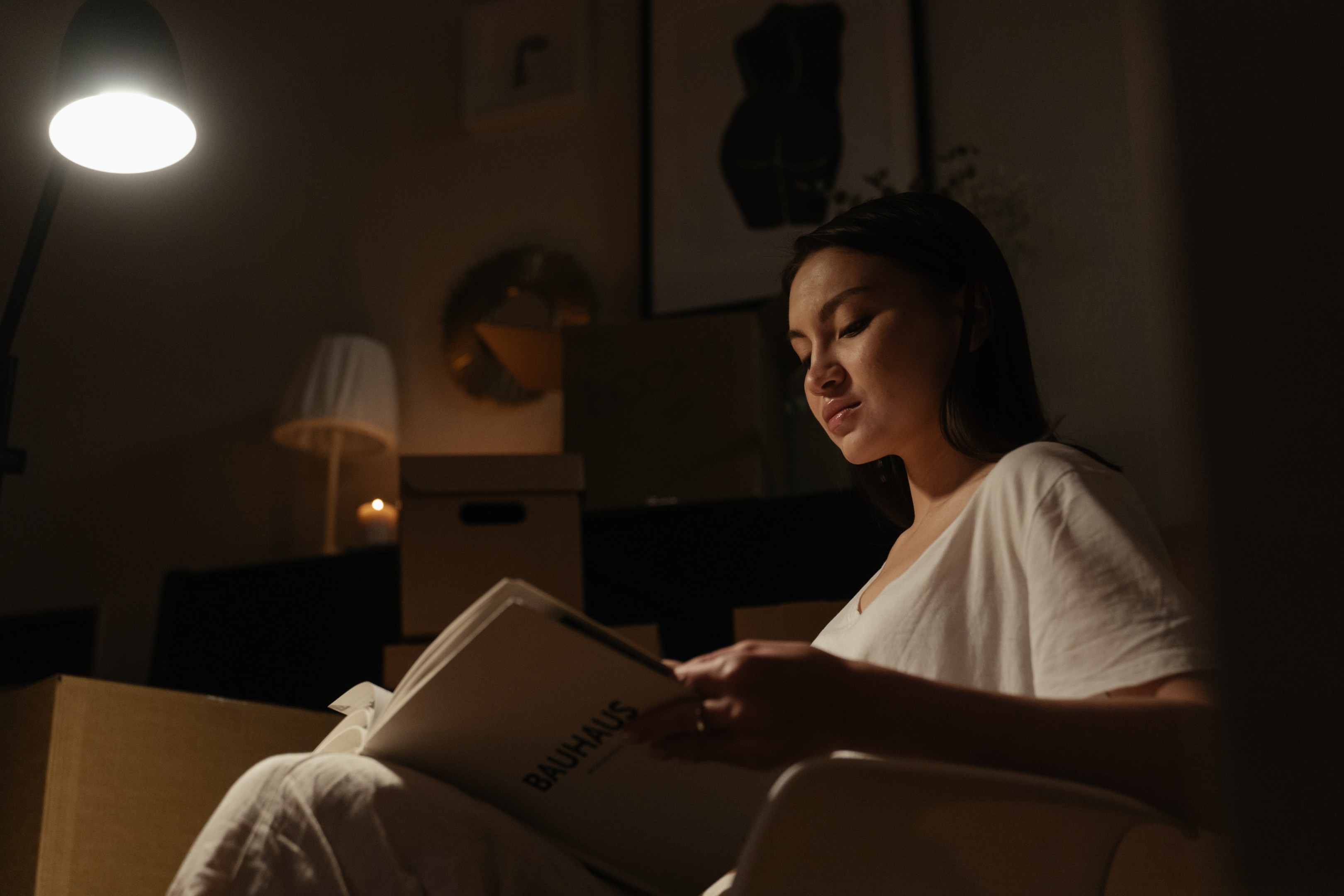 woman reading in chair with dimmed lighting 