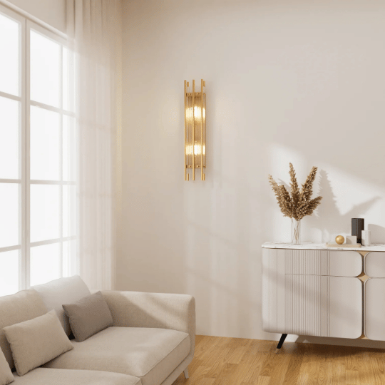 A modern entryway with a gold wall sconce mounted above a white console table, adding a warm and elegant glow to the minimalist space.