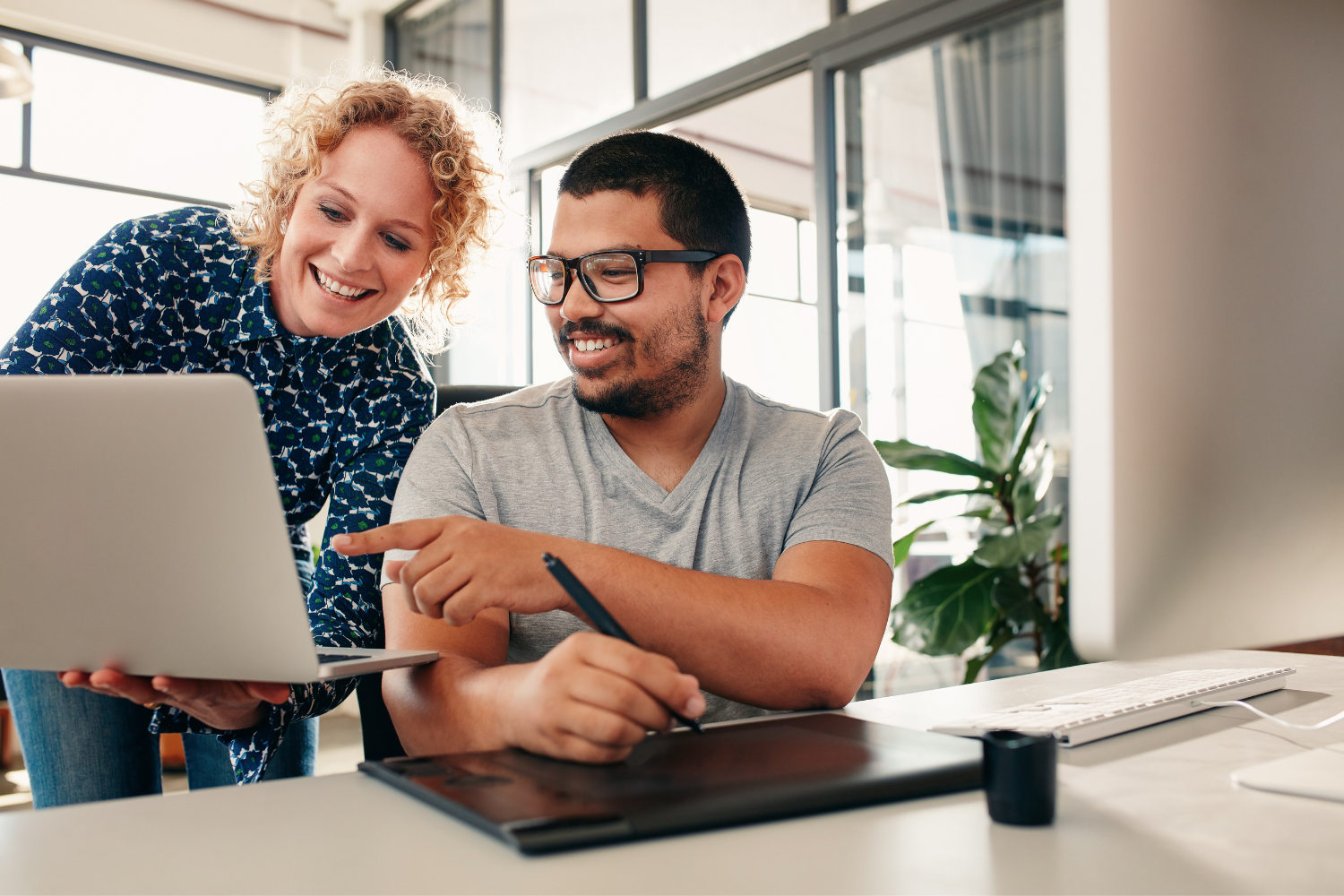 Manager and employee reviewing a task on a laptop.