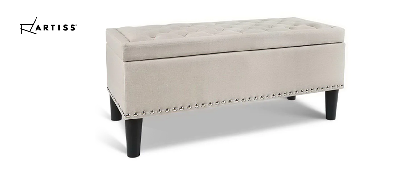 An Artiss beige fabric storage ottoman with a tufted top and nail head trim. 
