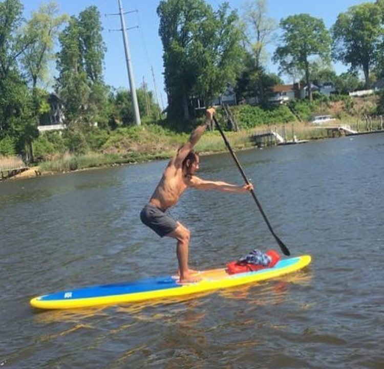 man paddling a stand up paddle board