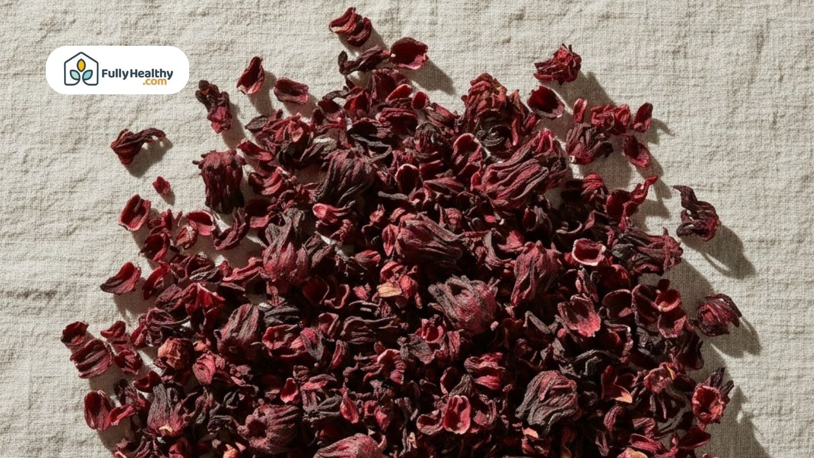 Dried hibiscus flowers on a neutral cloth surface.