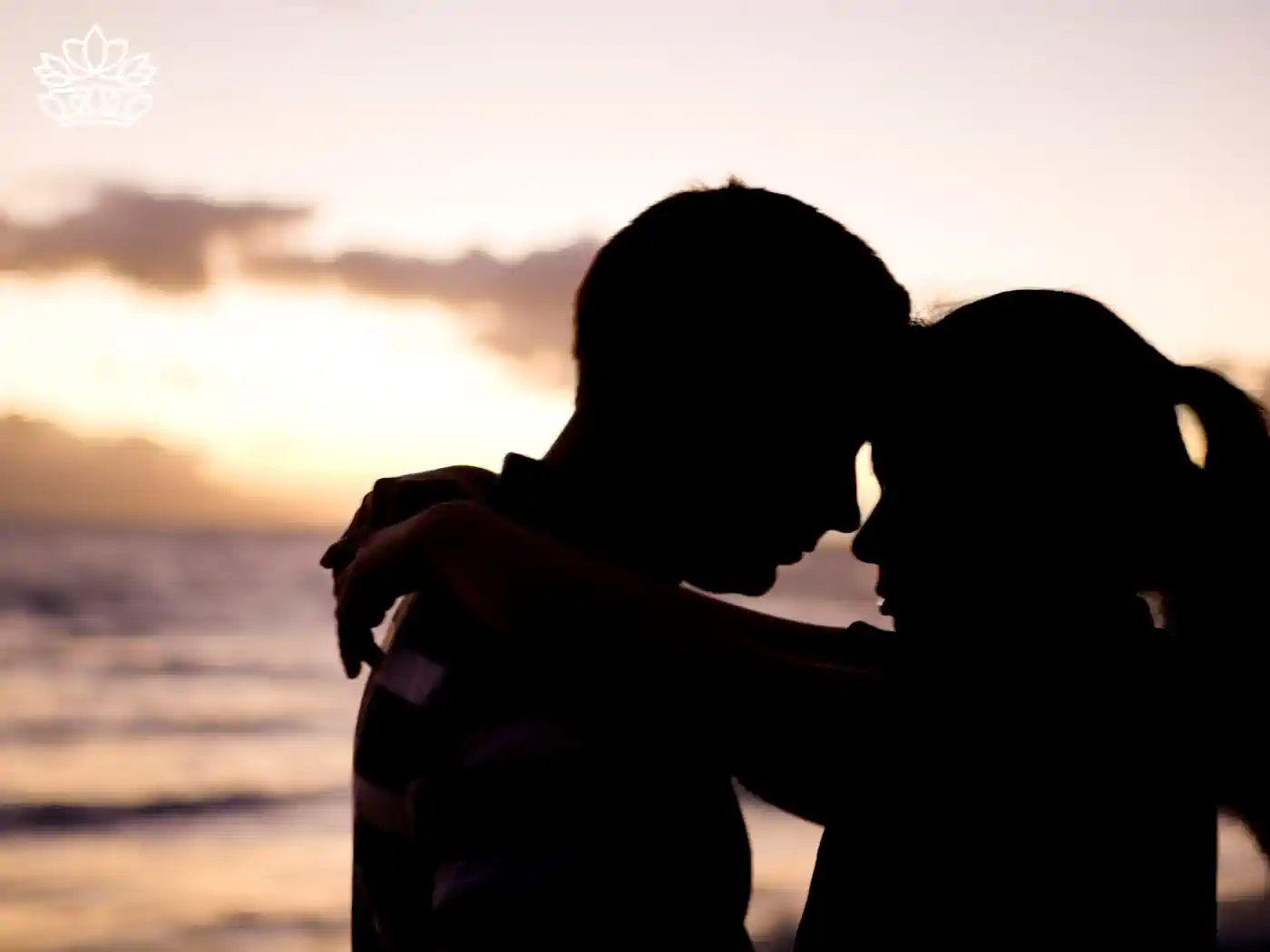 A couple embracing at sunset on a beach, creating a romantic atmosphere. Fabulous Flowers and Gifts. Romantic Flowers