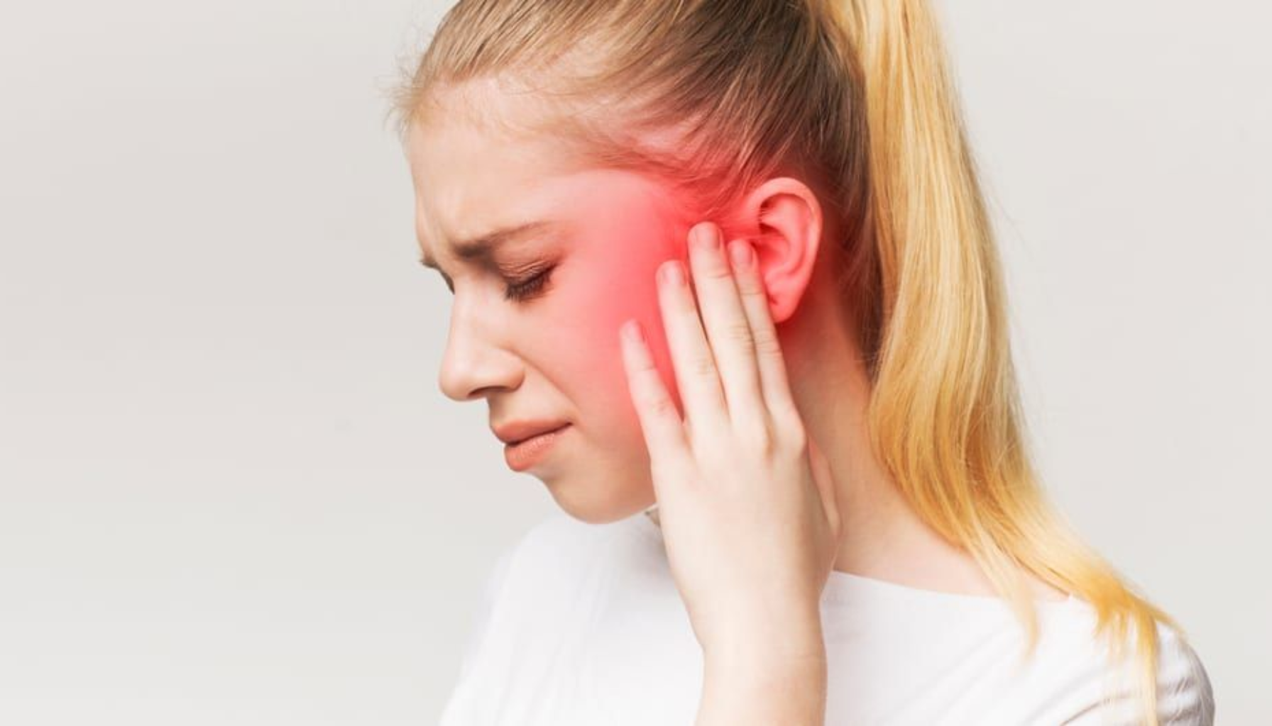 Trigeminusnevralgi: Når Ansiktssmerter Går fra Irriterende til Uutholdelig 10 Ung kvinne med smerte i øret holder hånden mot hodet, rødlig område viser mulig nerveirritasjon.