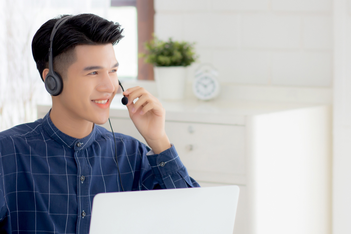 Filipino man smiling during a remote interview with headset on