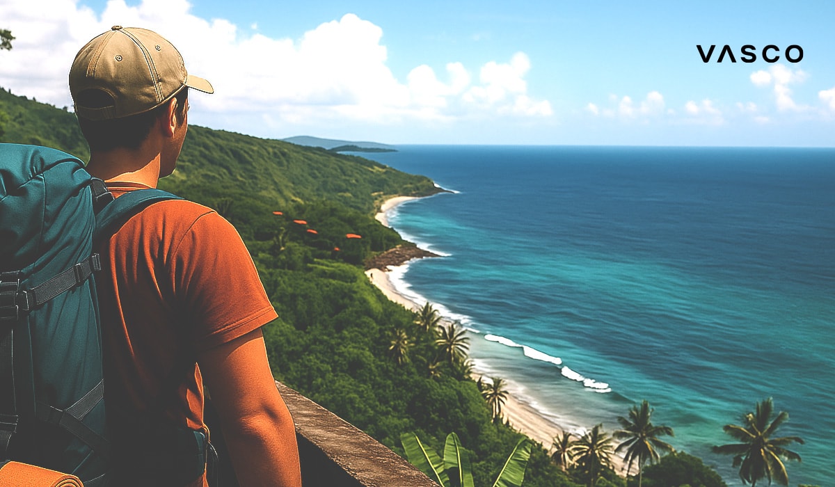 A hiker with a backpack enjoying the scenic view of the Bali coastline from a viewpoint.