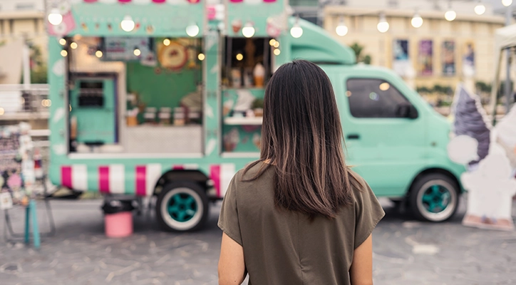 A lady going to a foodtruck.