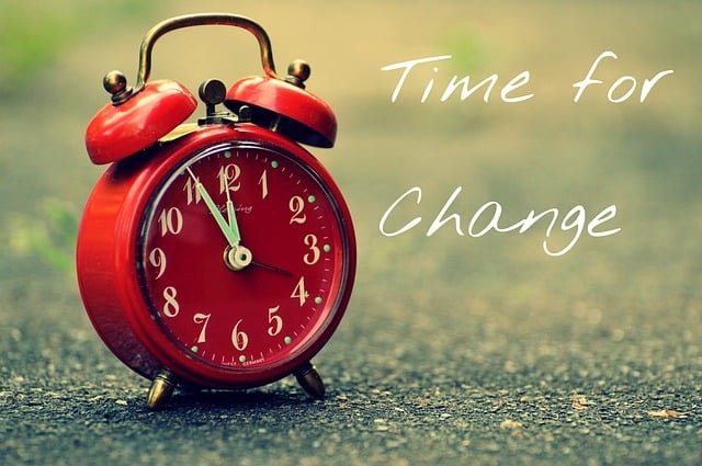 Red alarm clock with the phrase "time for change" next to it